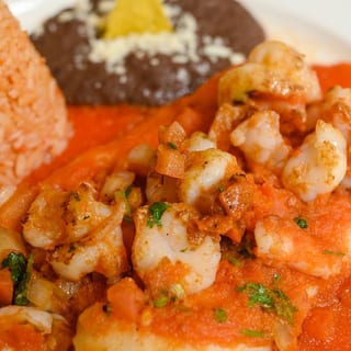 Red Shrimp Enchiladas / shrimps are on top and filled with cheese.